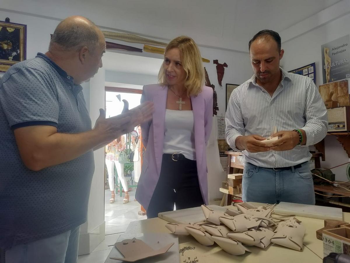 Almudena Martínez atiende las explicaciones de Paco Solano en la Exposición Permanente Manos y Magia en la Piel, en presencia de Mario Casillas.