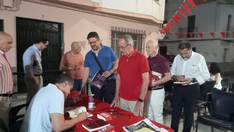 Roberto Arrocha firma ejemplares de sus libros.